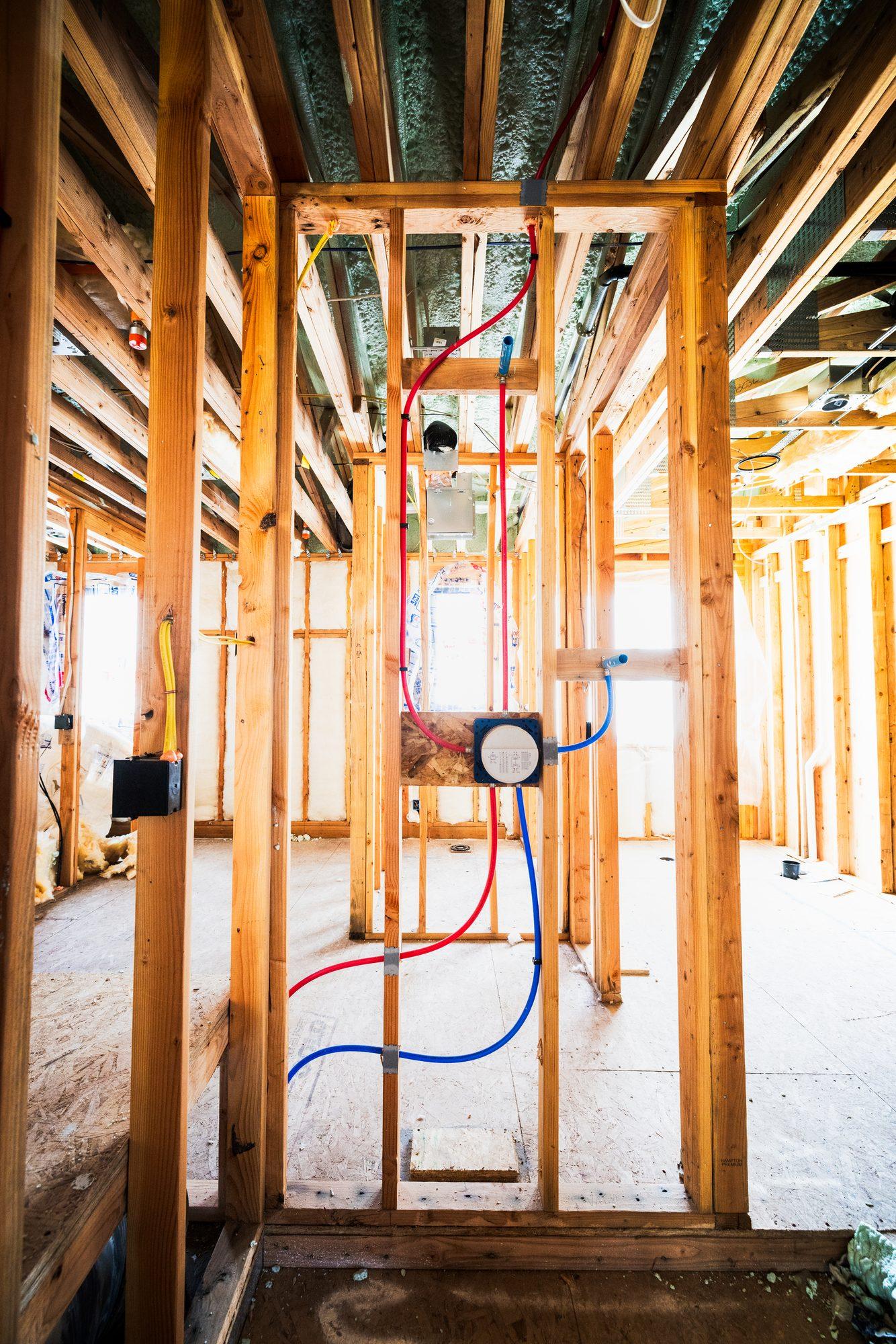 Vertical copper and PEX pipe rough-in in a framed wall